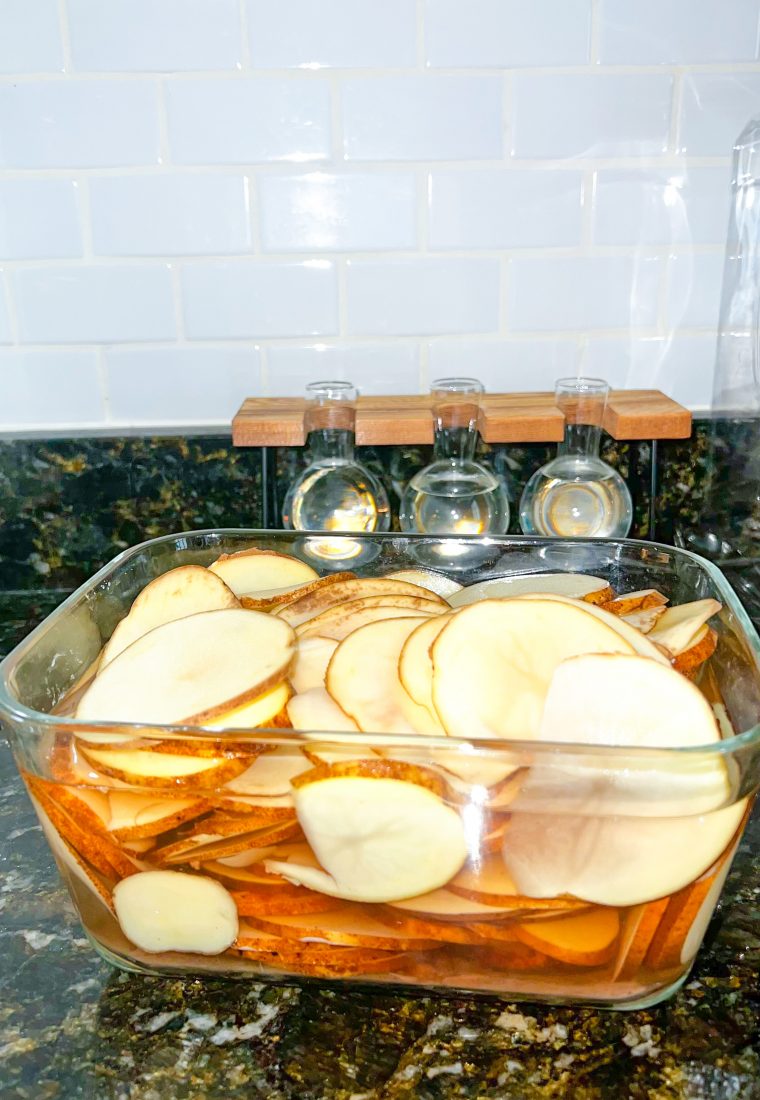 Potato slices soaking in saltwater before making scalloped potatoes.